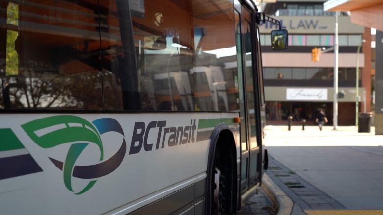 A side-on view of a bus parked at a station with 'BC Transit' painted on it.