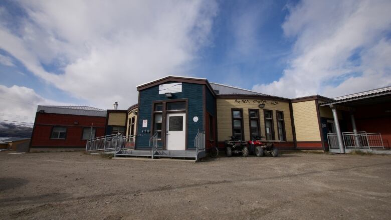 Exterior of a building with a blue entry-way and yellow walls.