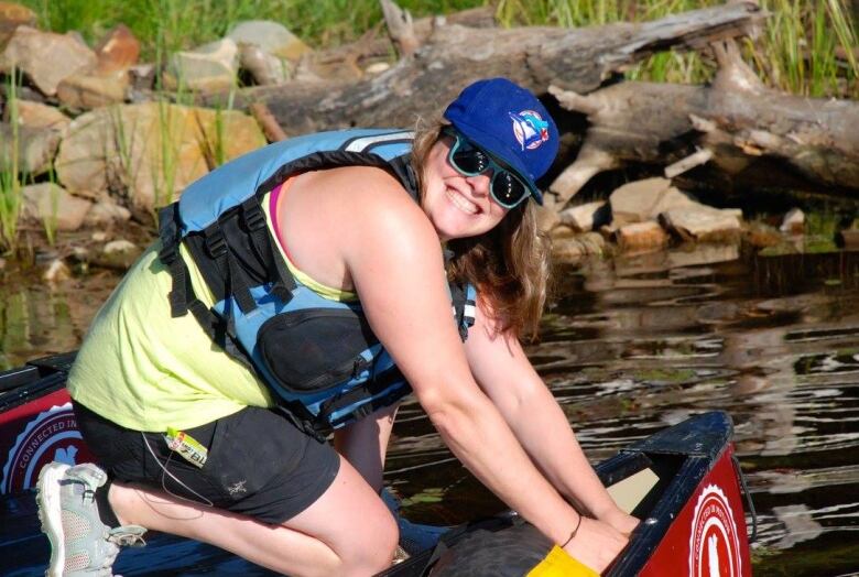 Jen Hanson smiles while she loads a canoe. 