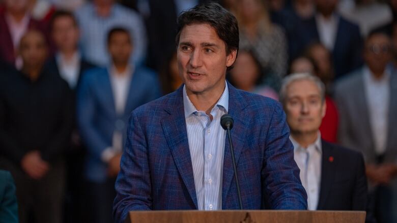 photo of justin trudeau with his caucus standing behind him in london ontario