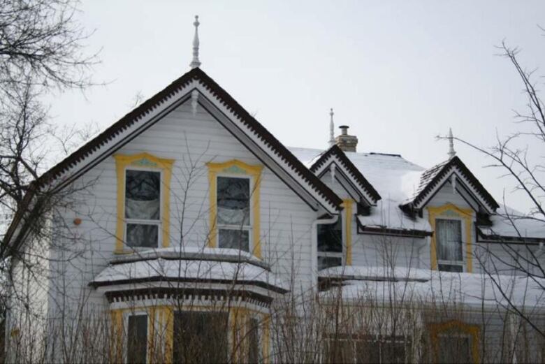 A white house with yellow window frames