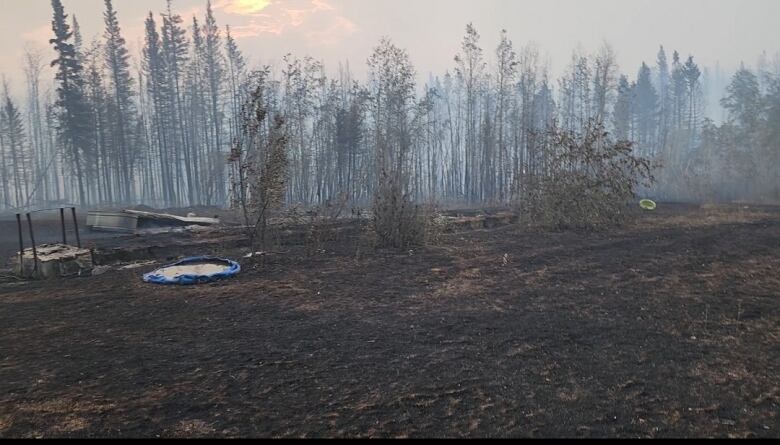 A burnt patch of ground, still smoking after a wildfire.