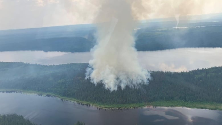 A wildfire burns between two bodies of water.