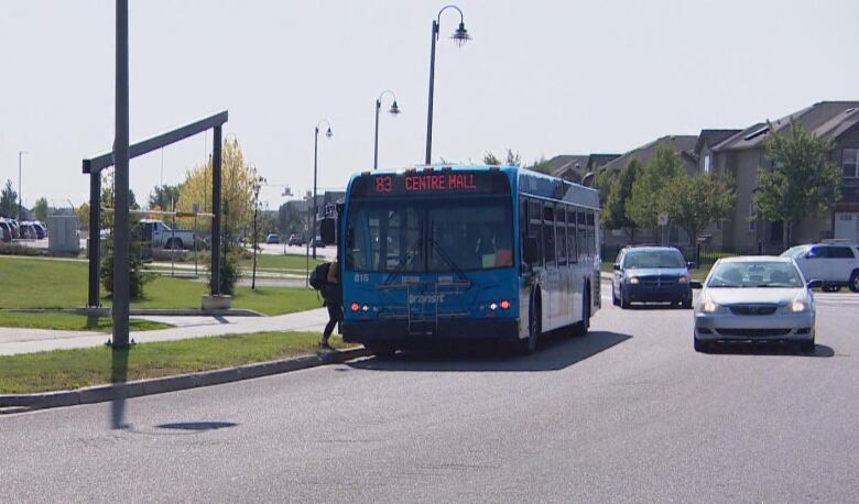 A city transit bus picks up a passenger