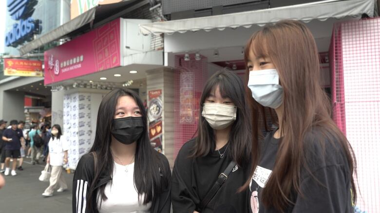 Three people are seen wearing face masks.