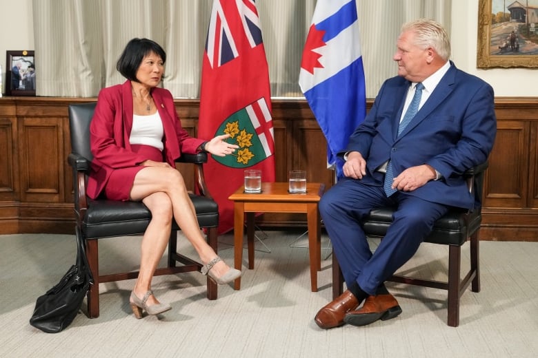 A man and woman sit in chairs talking.