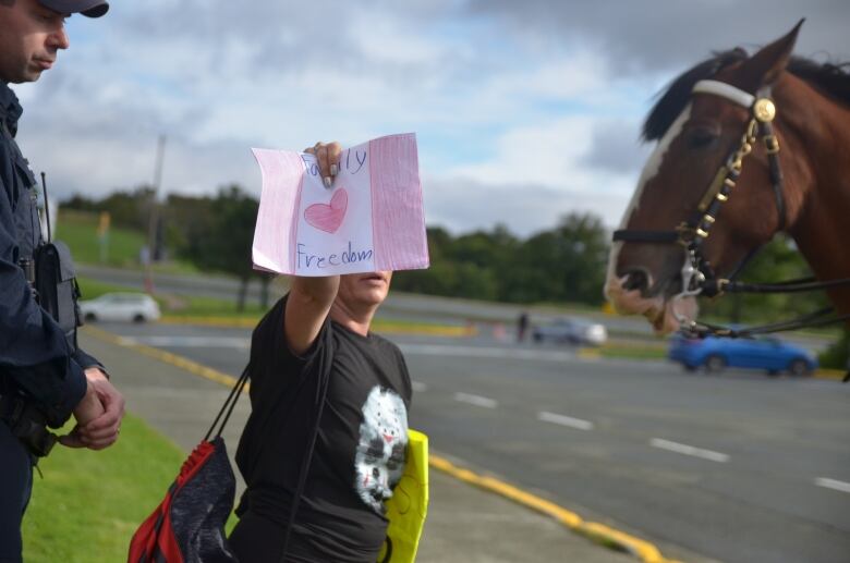 A woman holding a sign that reads 