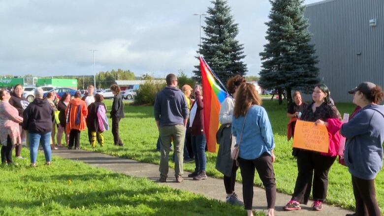 A group of people holding Pride flags. 