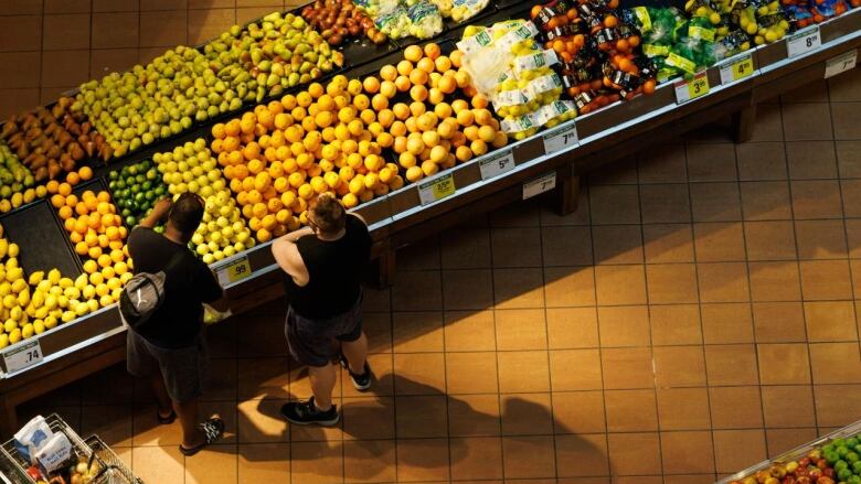 People shop in the produce aisle of a grocery store in Toronto, Monday, July 17, 2023. 