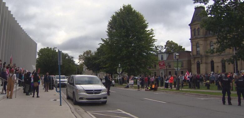 Two crowds of people gathered on either side of the street