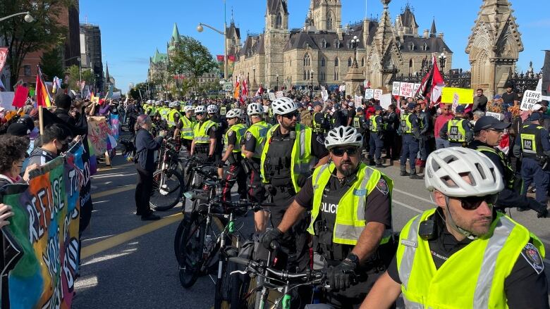 A line of police separate the two groups of demonstrators at Parliament Hill Wednesday, Sept. 20, 2023.