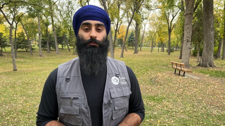 A man wearing a head covering stands on a lawn.