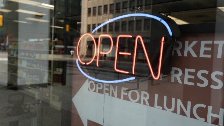 An open sign flashes through a window.