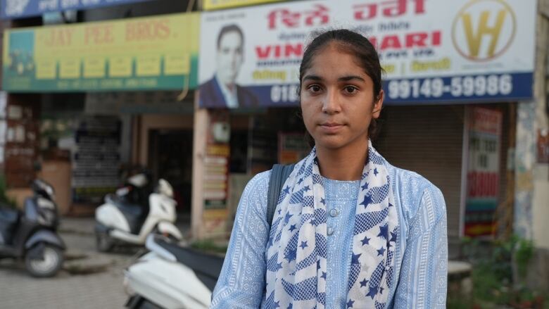 A woman stands on a street.