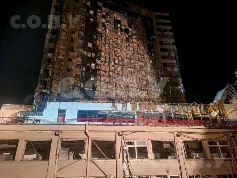 A view of a severely damaged, multistorey building at night. 