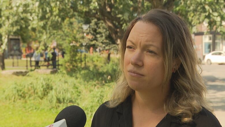 A women speaking into a CBC microphone. 