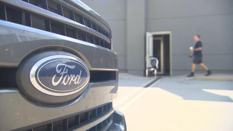 A grill of a truck focused on the Ford logo. 