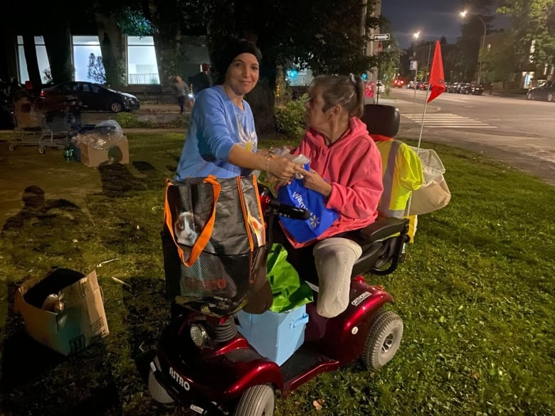 A person hands food to another person.