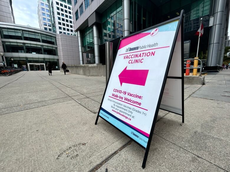 Sign outside Toronto's Metro Hall promoting a vaccination clinic for COVID-19 and school immunizations. 