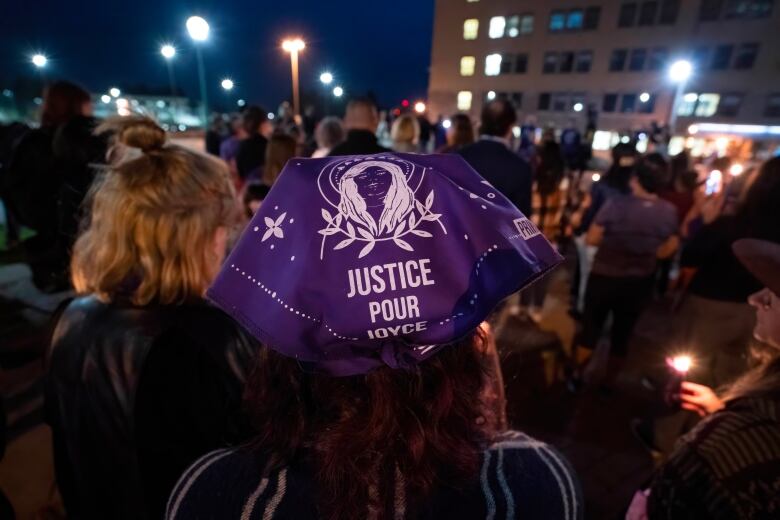 A woman wearing a purple headscarf with an image of Joyce Echaquan on it and the words 