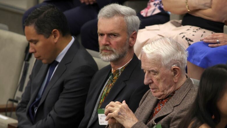 Three men sit in the House of Commons.