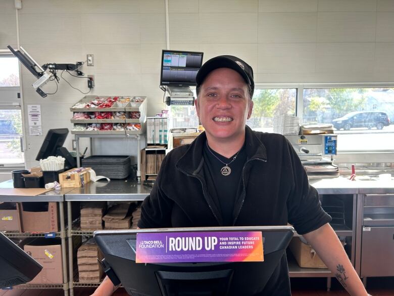 A woman in a black attire stands behind the counter.