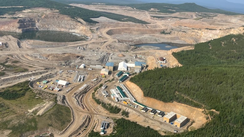 A mine site with large pits and a number of buildings 