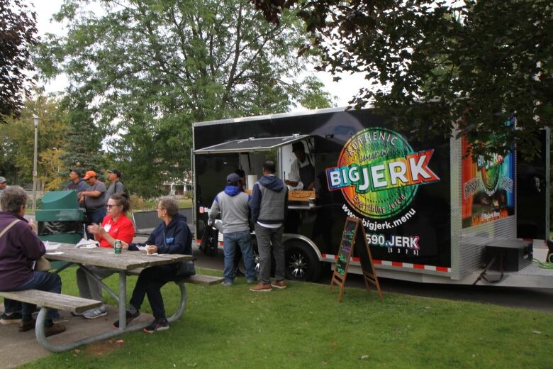 Two men getting food from a food truck.