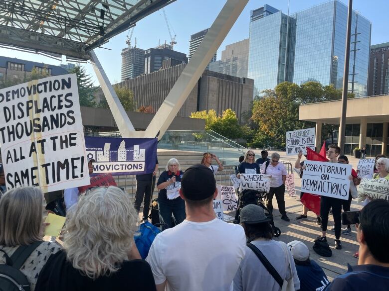 People hold signs at a protest.