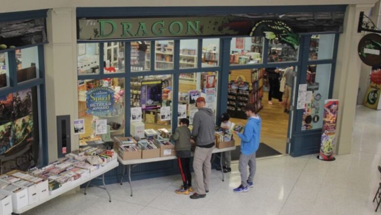 A group of people going through items outside a comic book store.