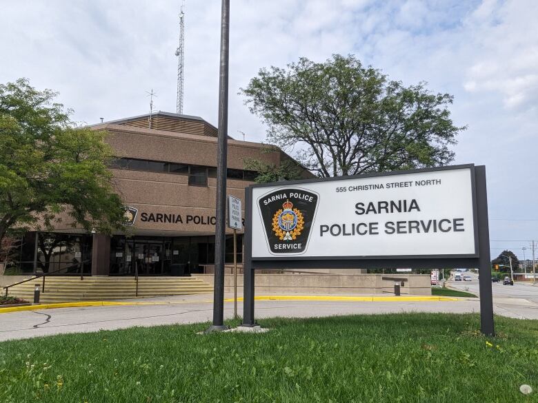 A brick building with a sign in front that says 