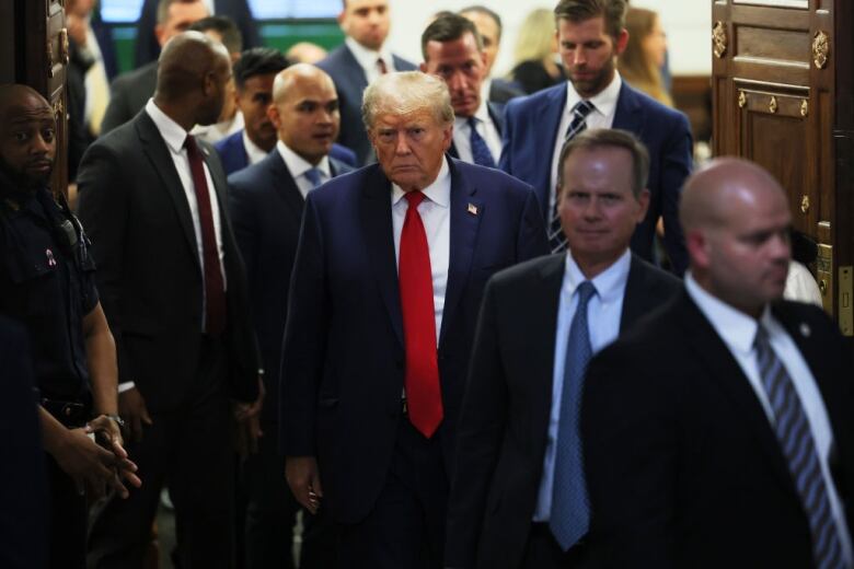 A group of men leave a courtroom.