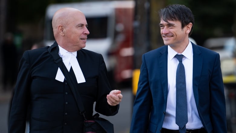 Cameron Jay Ortis, right, a former RCMP intelligence director accused of disclosing classified information, returns to the Ottawa Courthouse during a break in proceedings in Ottawa, on Tuesday, Oct. 3, 2023. 