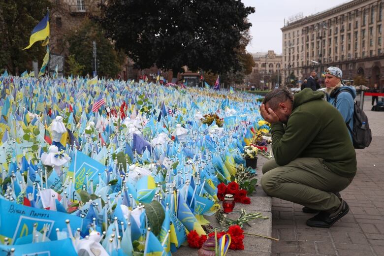 Ukrainians react during the All-National minute of silence in commemoration of Ukrainian soldiers killed in the country's war against Russia on Independence square in Kyiv, Ukraine, Sunday, Oct. 1, 2023. 