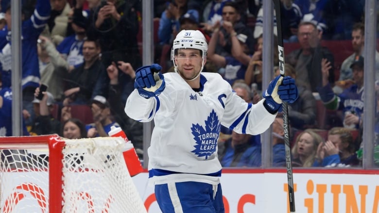 A hockey player points his glove in celebration.