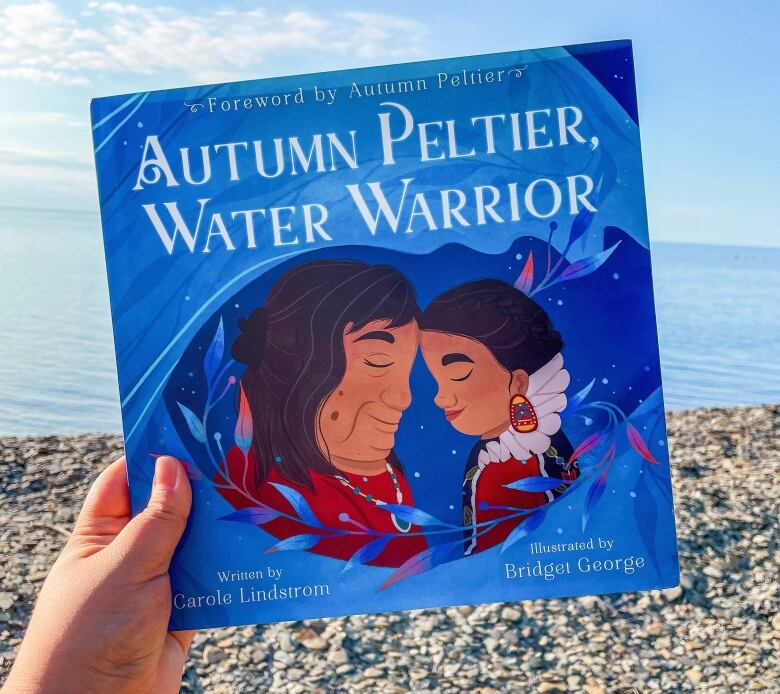 hand holding book on beach