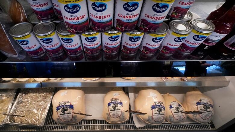 Turkey and cranberries are displayed on a Thanksgiving-themed store shelf.