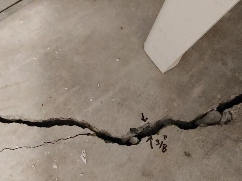 A large crack is shown in a concrete basement floor.