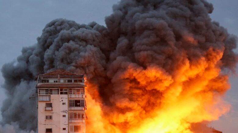 Smoke and flames billow from a Gaza high-rise tower after an Israeli airstrike.