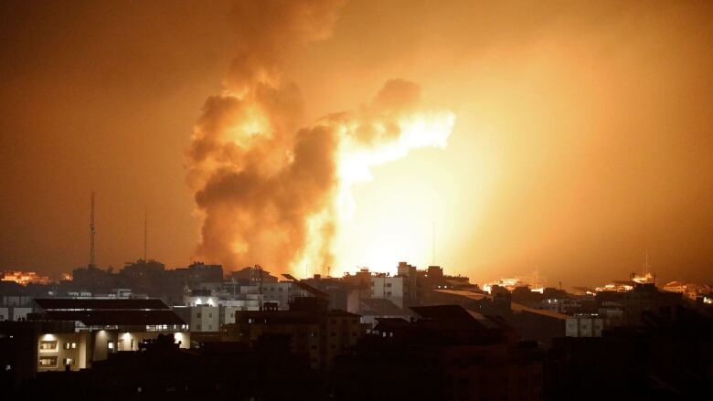 Fire and smoke rises above buildings.