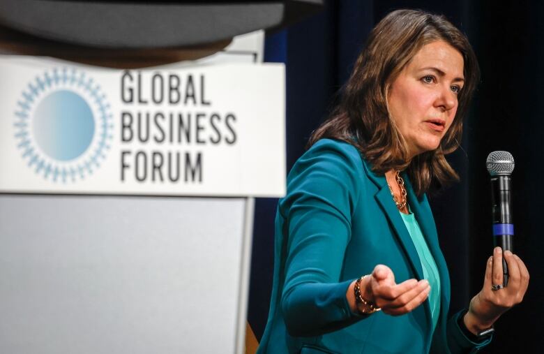 A woman speaks in front of a podium.