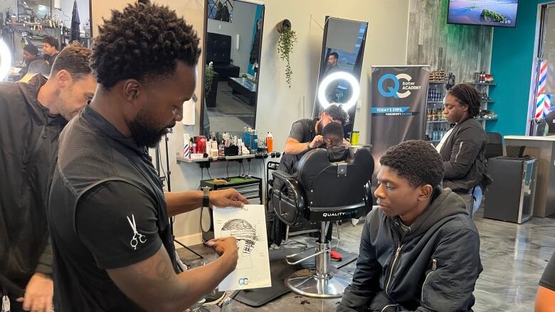 man teaching student in barbershop