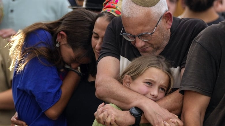 People weep at a funeral.