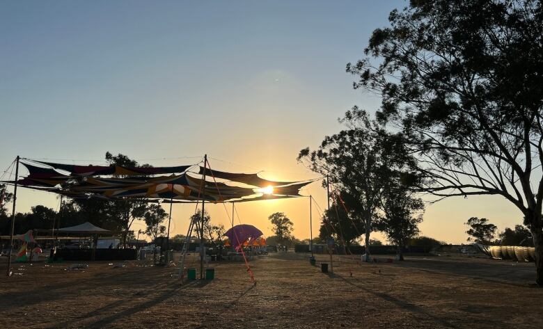 The sun sets over an abandoned music  festival  site