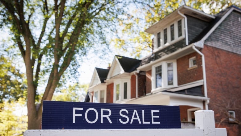 A for sale sign outside a house for sale in Toronto.