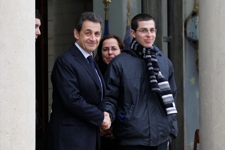 France's President Nicolas Sarkozy (L) shakes hands with Gilad Shalit, the Israeli soldier who was released in October 2011 after five years in captivity, on the steps of the Elysee Palace after their meeting in Paris February 8, 2012.   