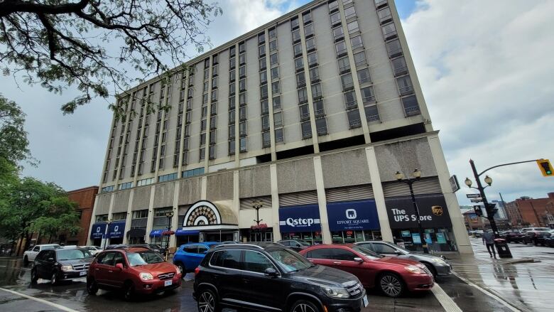 Cars pass in front of a building.