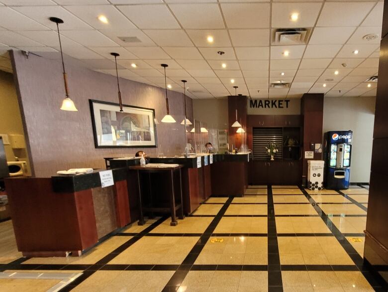 Wide shot of a hotel lobby with dark wood counters.