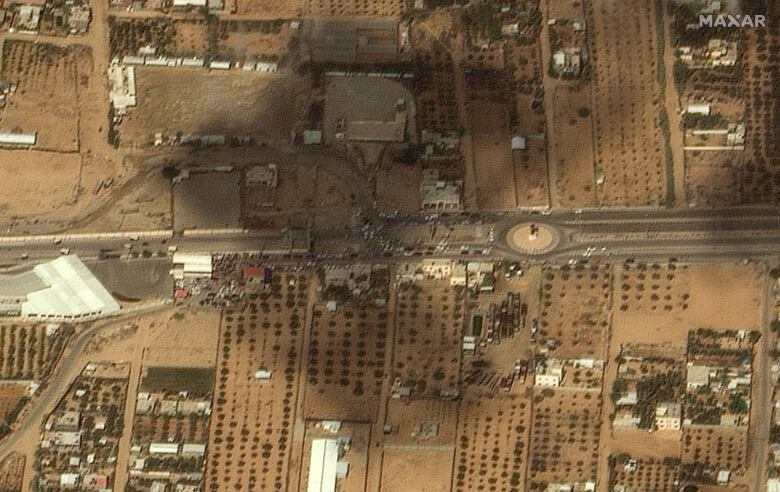 A satellite image shows crowds of people and vehicles, waiting to leave from the Gaza side of the border with Egypt, on Oct. 16, 2023.