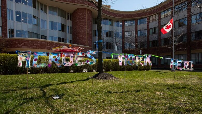 A display saying 'Heroes Work Here' is seen on the lawn in front of a building. 